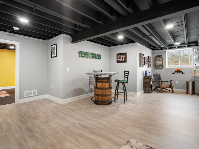 basement featuring baseboards, wood finished floors, and visible vents
