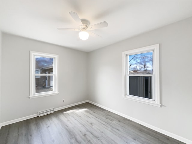 unfurnished room with visible vents, baseboards, ceiling fan, and wood finished floors