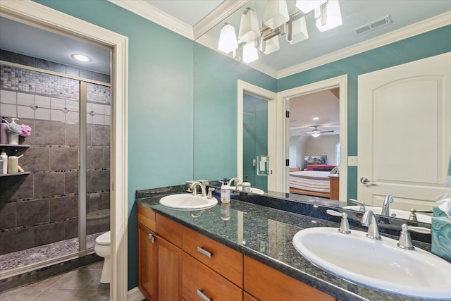 bathroom featuring a shower stall, toilet, double vanity, tile patterned floors, and ornamental molding