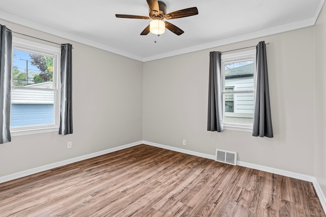 spare room with wood finished floors, baseboards, ceiling fan, and ornamental molding