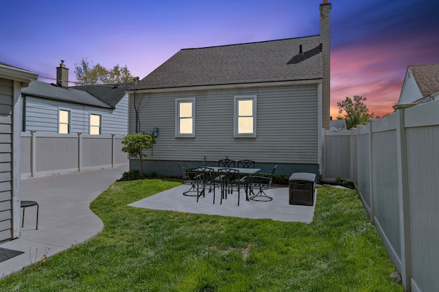 back of house featuring a patio area and roof with shingles
