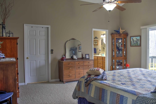 bedroom with a ceiling fan, connected bathroom, baseboards, light colored carpet, and a high ceiling