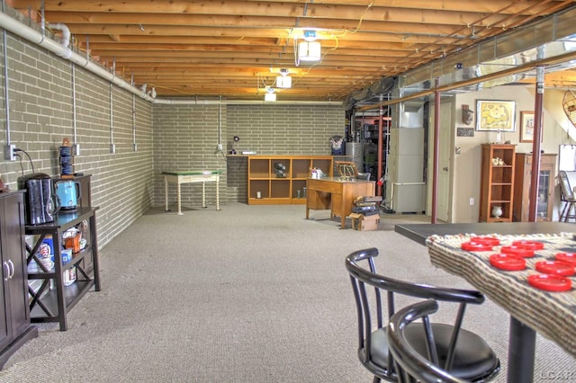 unfinished basement with brick wall and carpet floors
