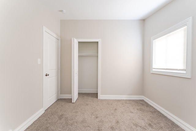 1182 Dudley Ave, Pontiac, MI 48342 - unfurnished bedroom featuring a closet, light colored carpet, and baseboards