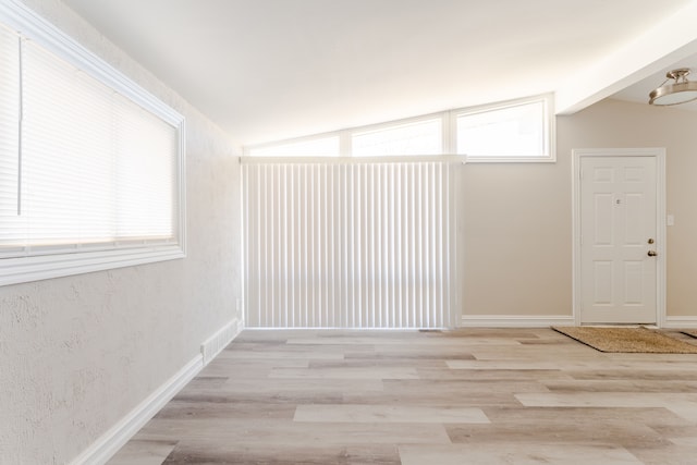 1182 Dudley Ave, Pontiac, MI 48342 - spare room with a wealth of natural light, vaulted ceiling, and light wood-style floors