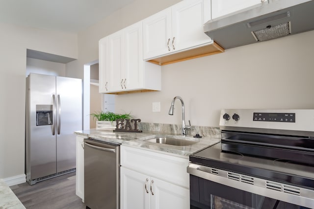 1182 Dudley Ave, Pontiac, MI 48342 - kitchen featuring light wood-style flooring, white cabinets, stainless steel appliances, range hood, and a sink