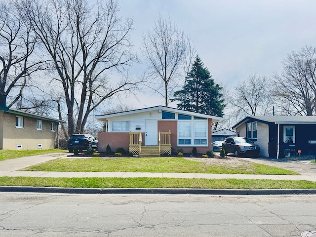 1182 Dudley Ave, Pontiac, MI 48342 - bungalow with brick siding, driveway, and a front lawn