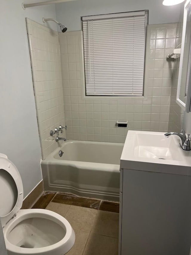 bathroom featuring vanity, toilet, tile patterned floors, shower / bathing tub combination, and baseboards