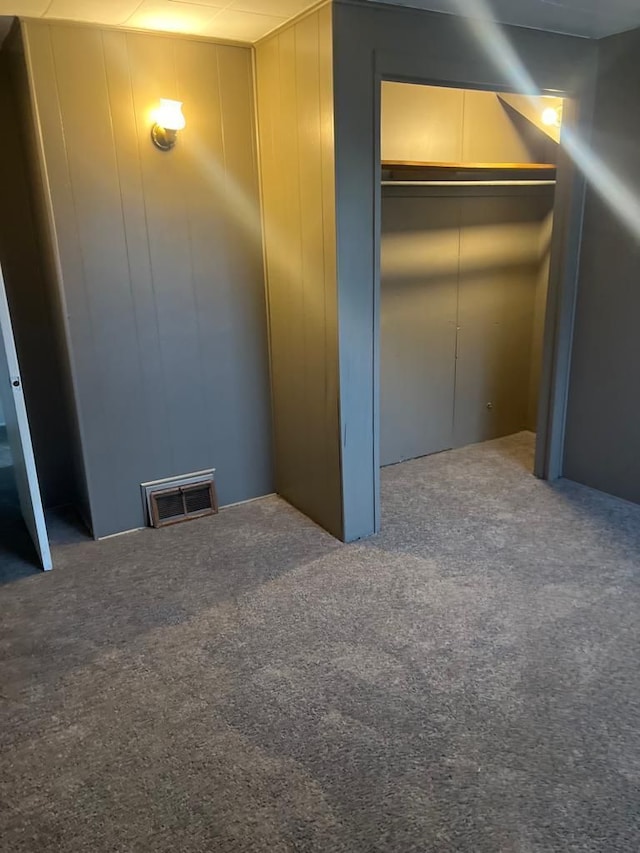 unfurnished bedroom with carpet flooring, visible vents, and a closet