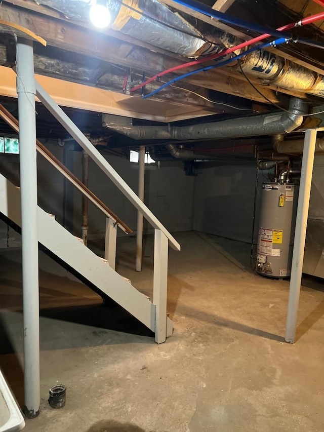 unfinished below grade area featuring water heater and stairs