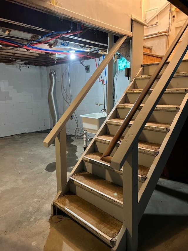 unfinished basement featuring a sink and concrete block wall