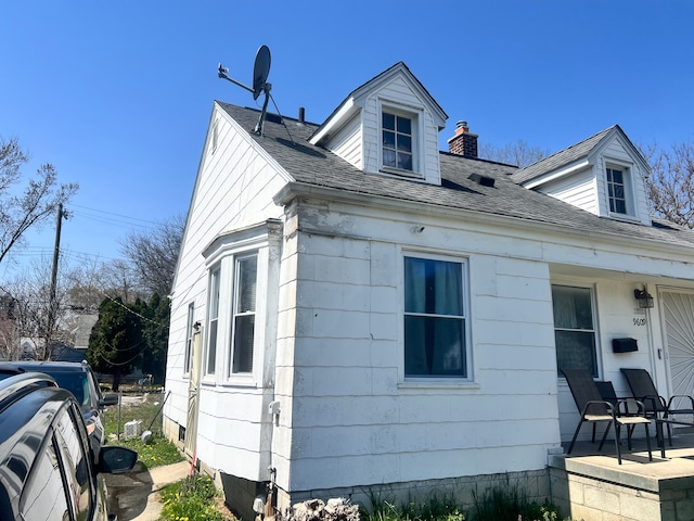view of home's exterior featuring a chimney and a shingled roof