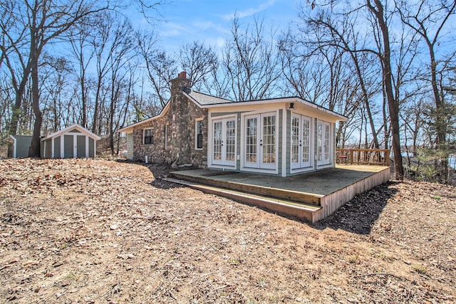201 Templar Ave, Pinckney, MI 48169 - back of house featuring stone siding, a shed, a chimney, french doors, and an outdoor structure