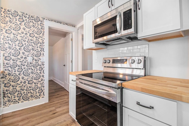 201 Templar Ave, Pinckney, MI 48169 - kitchen featuring wooden counters, baseboards, light wood-type flooring, white cabinetry, and stainless steel appliances