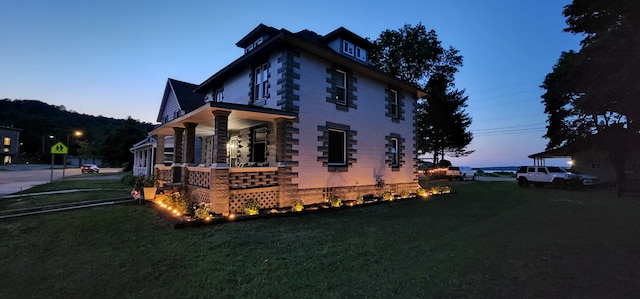 property exterior at dusk with a yard