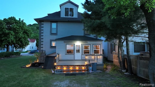 back of house featuring a yard, a deck, and fence