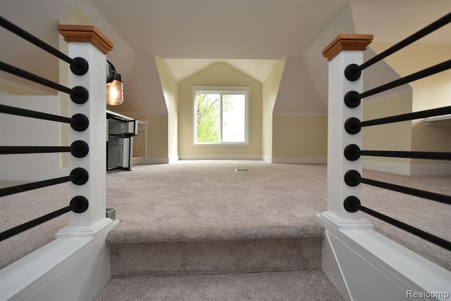 stairway with lofted ceiling, baseboards, and carpet floors