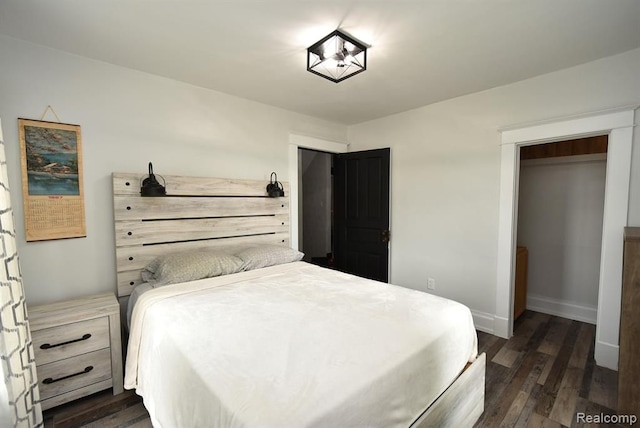 bedroom featuring dark wood-style flooring and baseboards