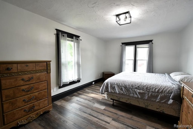 bedroom featuring baseboards and dark wood-style floors