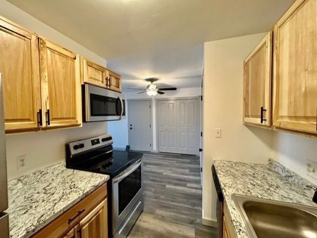 8741 Green Willow St Unit 11, Brighton, MI 48116 - kitchen featuring appliances with stainless steel finishes, a sink, ceiling fan, dark wood-type flooring, and light stone countertops