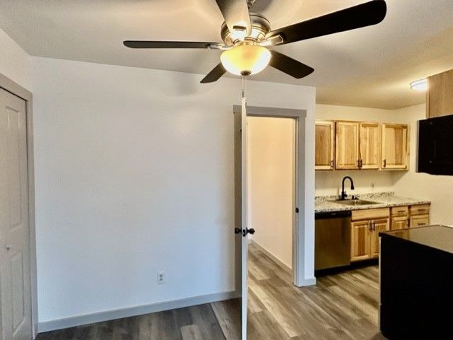 8741 Green Willow St Unit 11, Brighton, MI 48116 - kitchen with stainless steel dishwasher, a sink, wood finished floors, light countertops, and ceiling fan