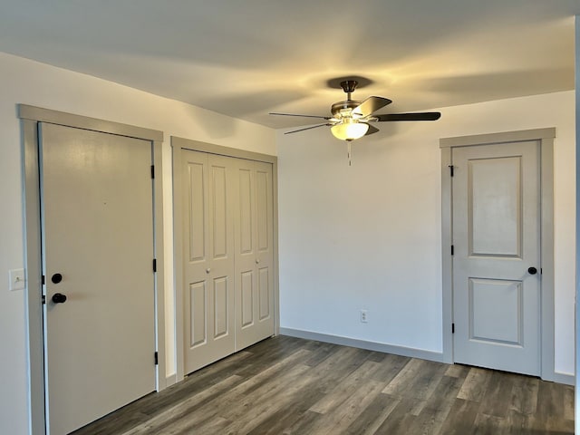 8741 Green Willow St Unit 11, Brighton, MI 48116 - unfurnished bedroom featuring dark wood-style flooring, multiple closets, a ceiling fan, and baseboards