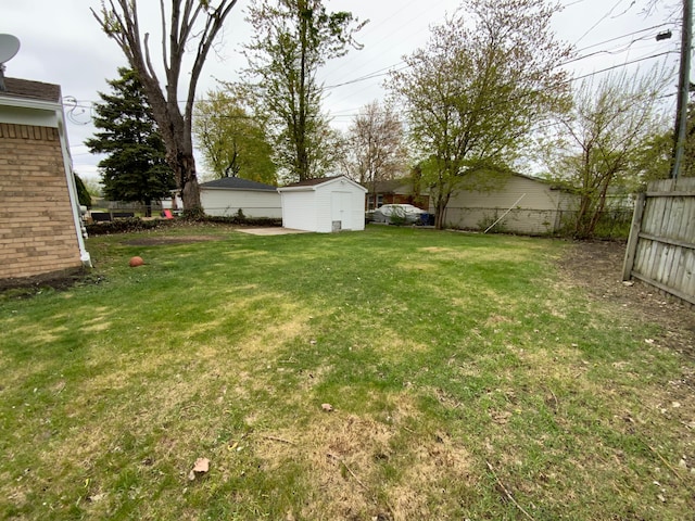 view of yard featuring an outbuilding, fence, and a storage unit