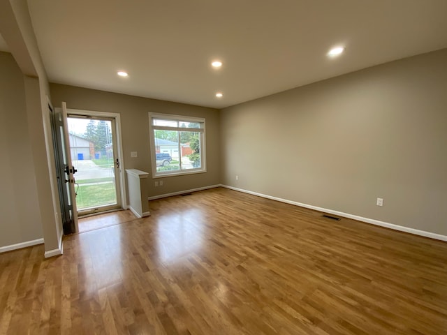 empty room featuring recessed lighting, baseboards, visible vents, and wood finished floors