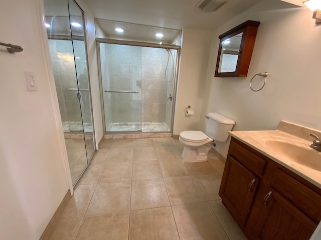 bathroom featuring toilet, vanity, visible vents, tile patterned flooring, and a shower stall
