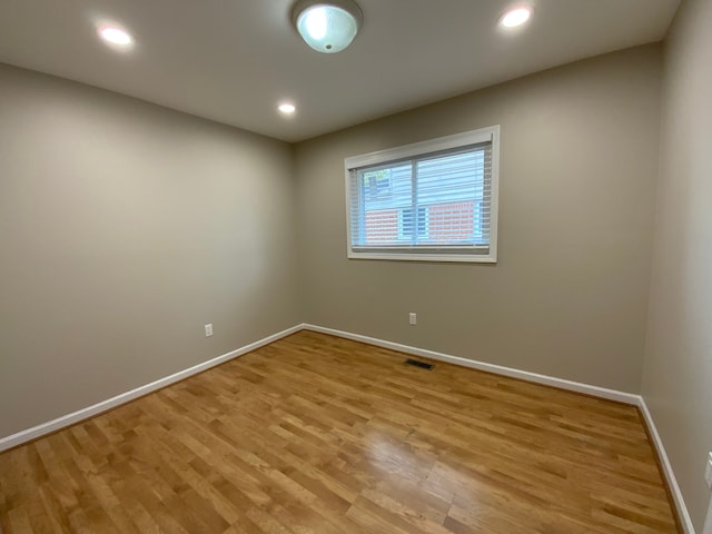 spare room featuring baseboards, light wood-style floors, and recessed lighting