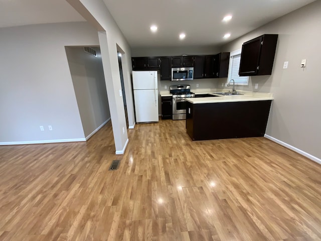 kitchen featuring baseboards, light countertops, stainless steel appliances, and a sink