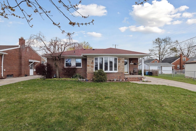 view of front of house with brick siding, driveway, a front yard, and fence