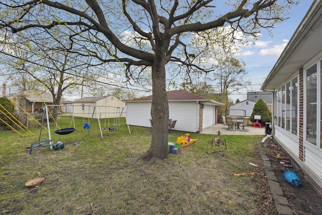 view of yard featuring a patio area, a detached garage, a playground, and an outdoor structure