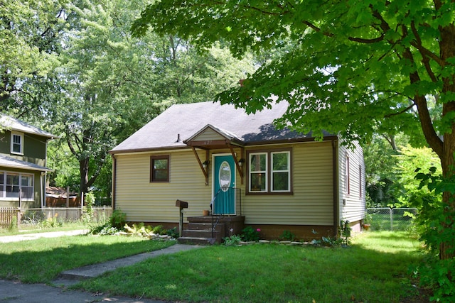 bungalow featuring a front yard and fence