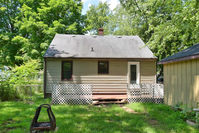 back of house featuring a yard, fence, a wooden deck, and a chimney