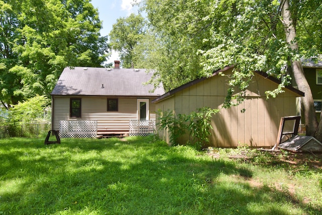 rear view of property with a chimney and a lawn