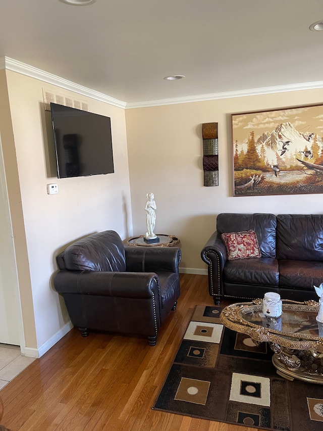 living room featuring wood finished floors, baseboards, and ornamental molding