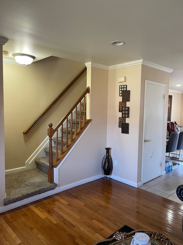 stairs with wood-type flooring, crown molding, baseboards, and recessed lighting