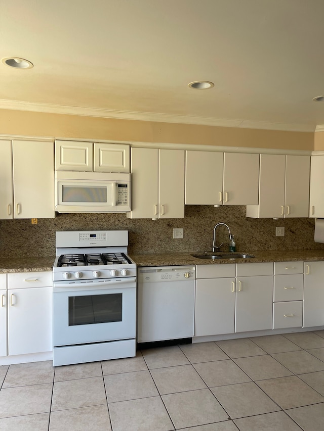 kitchen featuring white appliances, a sink, tasteful backsplash, and crown molding