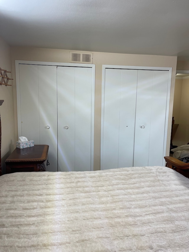 bedroom featuring visible vents and two closets