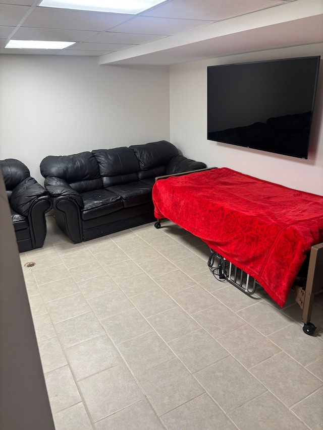 living area featuring light tile patterned floors and a drop ceiling