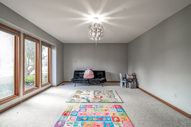 rec room featuring carpet floors, baseboards, and an inviting chandelier
