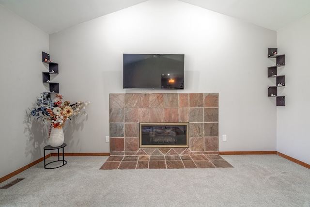 unfurnished living room with vaulted ceiling, visible vents, baseboards, a fireplace, and carpet flooring