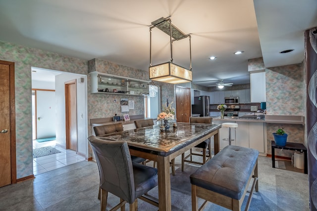 dining room with wallpapered walls and a ceiling fan