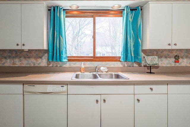 kitchen featuring white cabinets, dishwasher, light countertops, and a sink