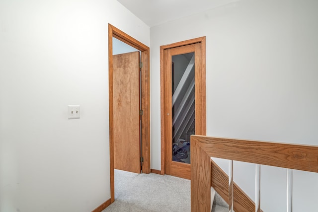 corridor with carpet floors and baseboards
