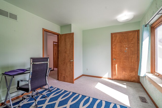 carpeted office featuring baseboards, visible vents, and a healthy amount of sunlight