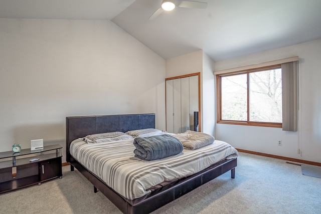 carpeted bedroom with baseboards, lofted ceiling, a ceiling fan, and a closet