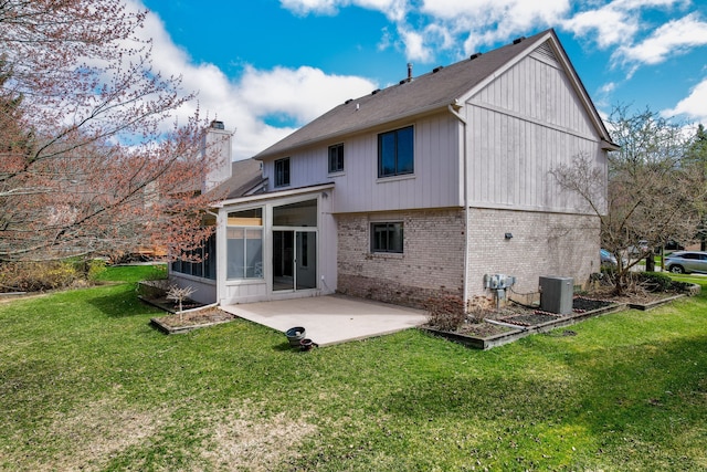 back of house featuring central AC unit, brick siding, a patio area, a lawn, and a sunroom