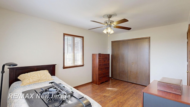 bedroom featuring wood finished floors, a closet, a ceiling fan, and baseboards